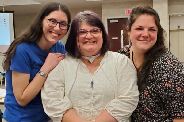 Dani Laurion flanked by two friends at a church potluck following her healing. Doug Laurion