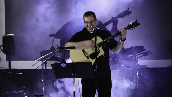 Member of music group "Priests in Concert" performs on stage at event raising money for WYD2023 in Lisbon, Portugal. Photo courtesy of Priests in Concert