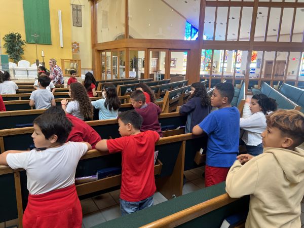 Fifth graders pray at adoration at Sacred Heart School. Credit: Dalia Gibson
