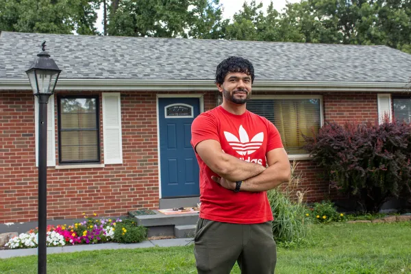 Farid Wardak, an Afghan immigrant, proudly stands in front of the house that Ann and Frank Wittman purchased for his family in the St. Louis suburb of Affton. Farid, who now works a manufacturing job in nearby Fenton, hopes to buy the house from the Wittmans someday. Jonah McKeown/CNA. Jonah McKeown/CNA