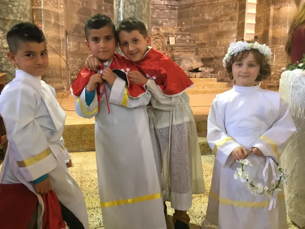 Young altar servers from Mar Kyriakos in Batnaya, Iraq, on Easter 2017. The town was not yet reinhabited (there was no power or water and parts of the town were still mined), but the church had been cleaned up enough so that Easter Mass could be celebrated there. Courtesy of Stephen Rasche