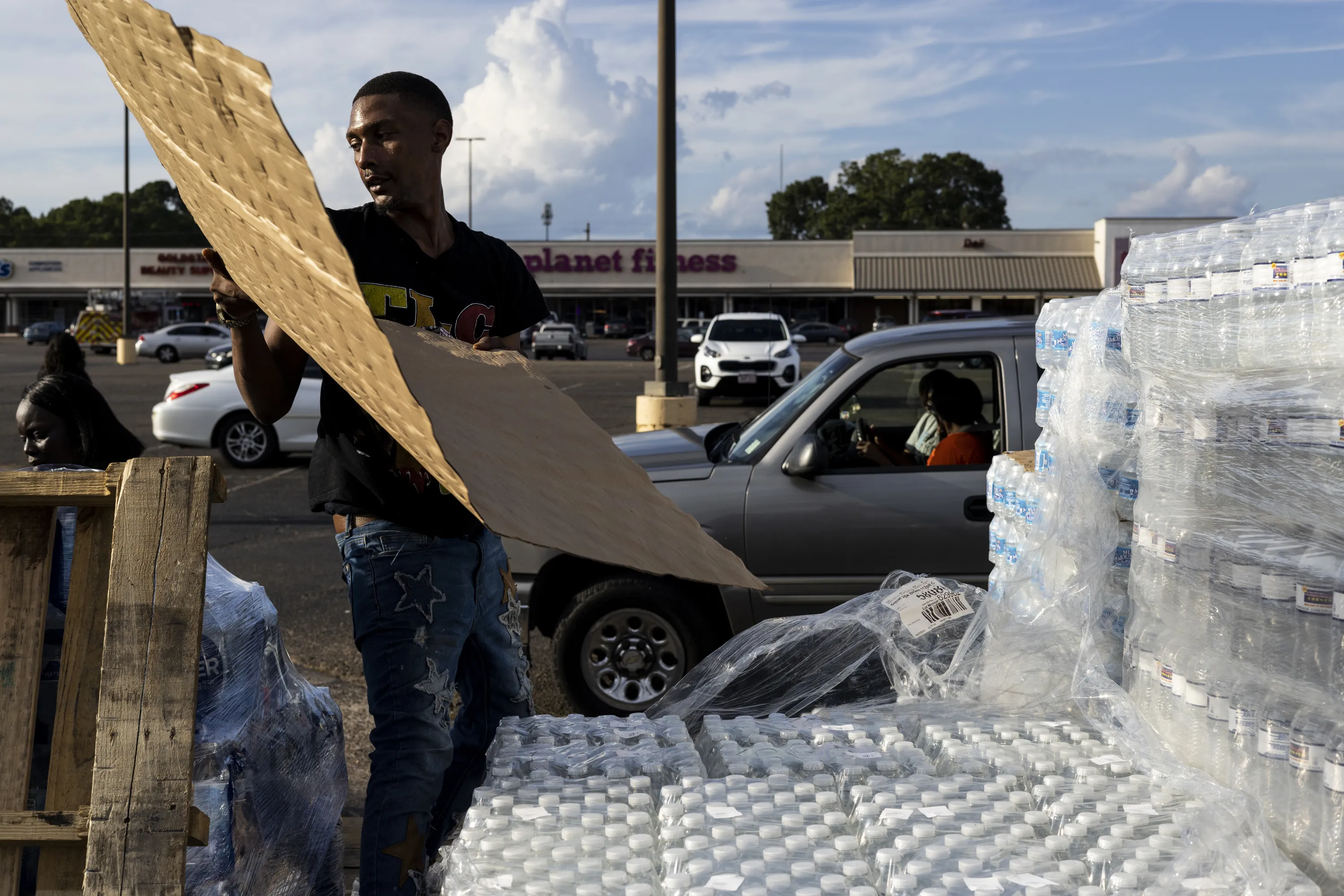 Dontavious Spann helps hand out cases of bottled water at a Mississippi Rapid Response Coalition distribution site on Aug. 31, 2022 in Jackson, Mississippi.?w=200&h=150