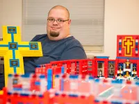 John Kraemer holds a large Lego cross that will form the basis for his church building's roof.