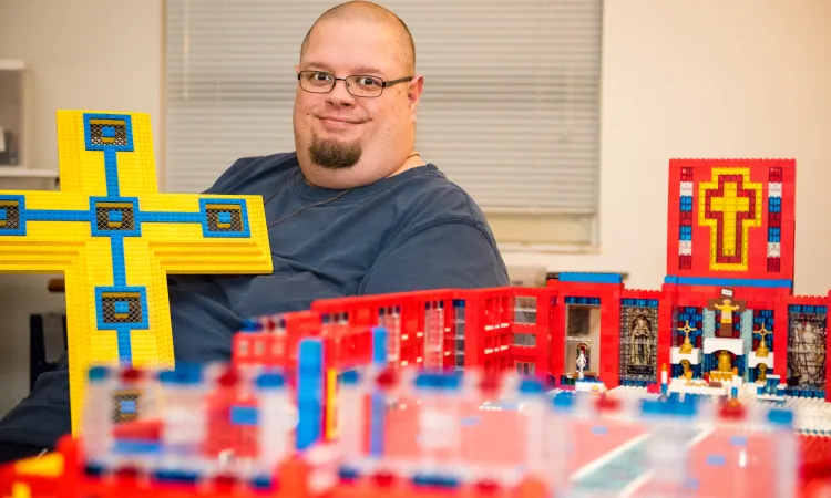 John Kraemer holds a large Lego cross that will form the basis for his church building's roof.
