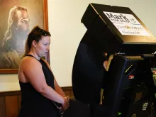 A poll worker helps a voter cast their ballot in the Kansas Primary Election at Merriam Christian Church on Aug. 2, 2022, in Merriam, Kansas. Voters in Kansas were set to decide whether or not the state constitution should include a right to an abortion.