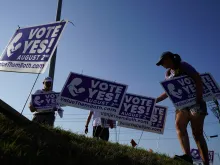 Supporters of the Vote Yes to a Constitutional Amendment on Abortion remove signs along 135th Street on Aug. 1, 2022, in Olathe, Kansas.