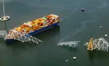 In an aerial view, the cargo ship Dali sits in the water after running into and collapsing the Francis Scott Key Bridge on March 26, 2024, in Baltimore.