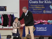 Supreme Knight Patrick Kelly gives the millionth coat to a little girl at Annunciation Catholic School in Denver, Colorado,