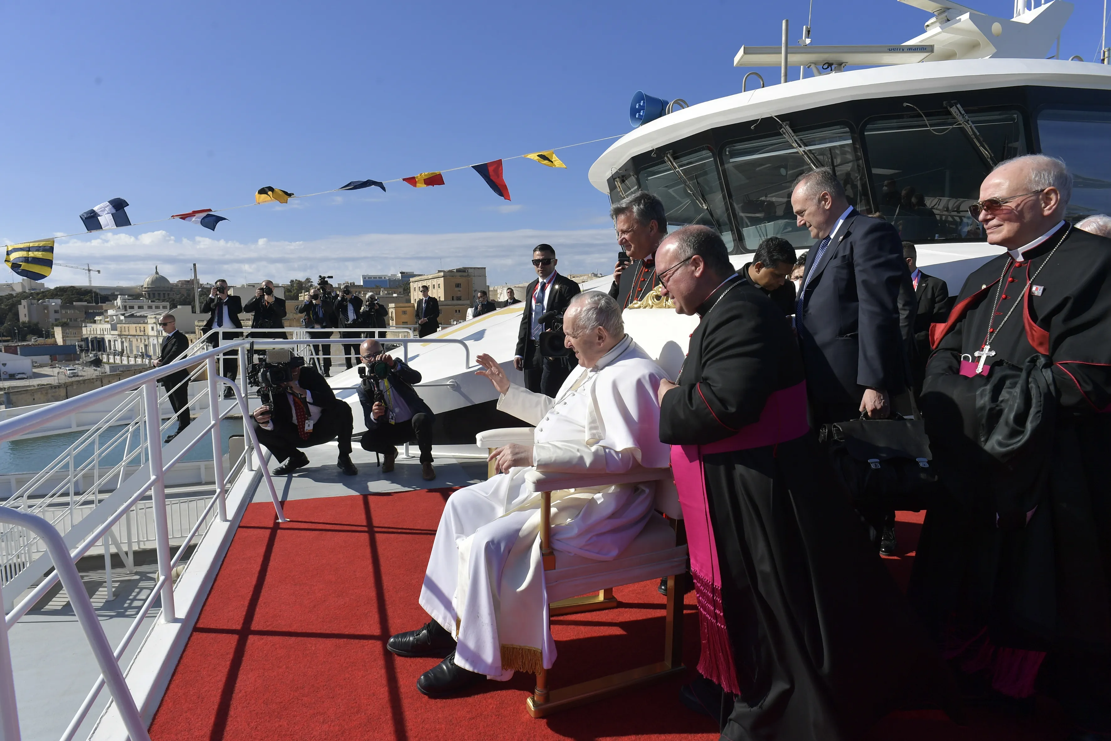 Pope Francis waves to children while he waits aboard a catamaran to depart for the Maltese island of Gozo where would lead a prayer service on April 2, 2022.?w=200&h=150