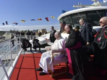 Pope Francis waves to children while he waits aboard a catamaran to depart for the Maltese island of Gozo where would lead a prayer service on April 2, 2022.