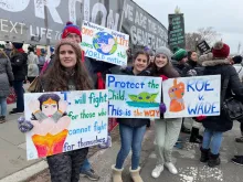 Young adults hold colorful signs outside the U.S. Supreme Court at the March for Life in Washington, D.C., on Jan. 21, 2022.
