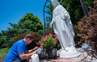A man removes red spray paint from a statue of the Blessed Mother at the Church of the Ascension in Overland Park, Kansas. Kathryn White/The Leaven
