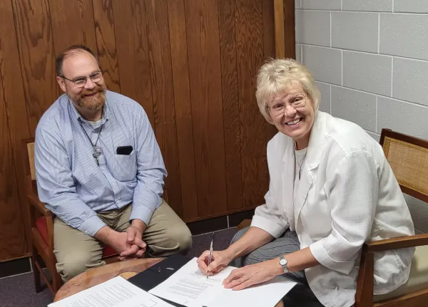 Steve Splonskowski, executive director of the newly formed Maryvale Corporation, and Sister Suzanne Stahl, Regional Superior of the Sisters of Mary of the Presentation, sign the agreement turning Maryvale over to the corporation and the Diocese of Fargo. Courtesy of the Diocese of Fargo