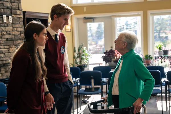 Young people from the St. John Choir Schola talk with a resident of the Evanston Summit Retirement Residence in Calgary, Alberta, after the "Mass of a Lifetime." Credit: Amanda Achtman