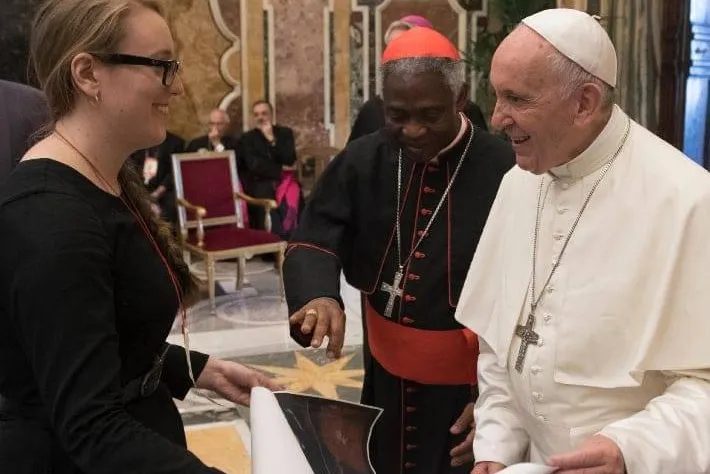 Molly Burhans presents one of her maps to Pope Francis and Cardinal Peter Turkson at the Vatican during summer 2018.?w=200&h=150