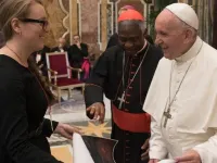 Molly Burhans presents one of her maps to Pope Francis and Cardinal Peter Turkson (center) at the Vatican during summer 2018.