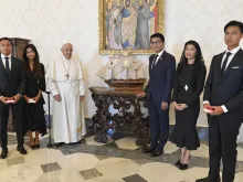 Pope Francis poses next to a miniature model of a ship with Madagascar's President Andry Nirina Rajoelina and his family in the Vatican's apostolic palace on Aug. 17, 2023.