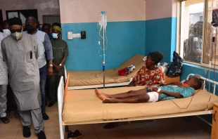 State officials walk past injured victims on hospital beds being treated for wounds following an attack by gunmen at St. Francis Xavier Catholic Church in Owo, southwest Nigeria, on June 5, 2022. AFP via Getty Images