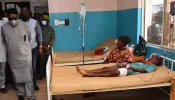 State officials walk past injured victims on hospital beds being treated for wounds following an attack by gunmen at St. Francis Xavier Catholic Church in Owo, southwest Nigeria, on June 5, 2022.