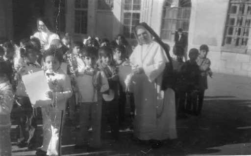 A photo of a Chaldean Catholic nun with school children circa 1985. Credit: Photo courtesy of Georgena Habbaba