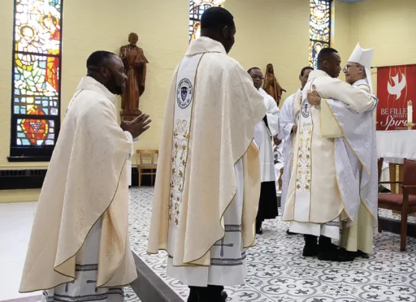 Bishop John H. Ricard welcomes Ugochukwu Henry Ihuoma (from left), George Agwu Liwhuliwhe and Wisdom Umanah to the altar during the ordination liturgy June 3, 2023, at St. Luke Church in Washington, D.C. Credit: The Josephites