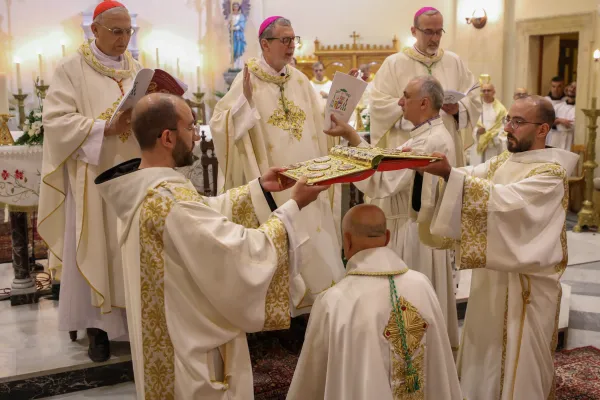 The central moment of the ordination rite: the laying on of hands on the head of the elect by the bishops and the solemn prayer of ordination, by which the gift of the Holy Spirit for episcopal ministry is conferred on the elect. The bishop-elect is on his knees and two deacons hold the book of the Gospels open over his head. Credit: Photo courtesy of TEWK CENTRE
