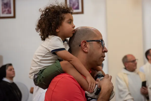 A man carries his daughter on his shoulders at a Mass in celebration of the feast day of Our Lady, Queen of Palestine and the Holy Land at the shrine dedicated to her at Deir Rafat on Sunday, Oct. 29, 2023. Credit: Marinella Bandini