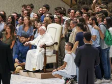 Pope Francis poses for a photo with a group of young people after his general audience Aug. 17, 2022.