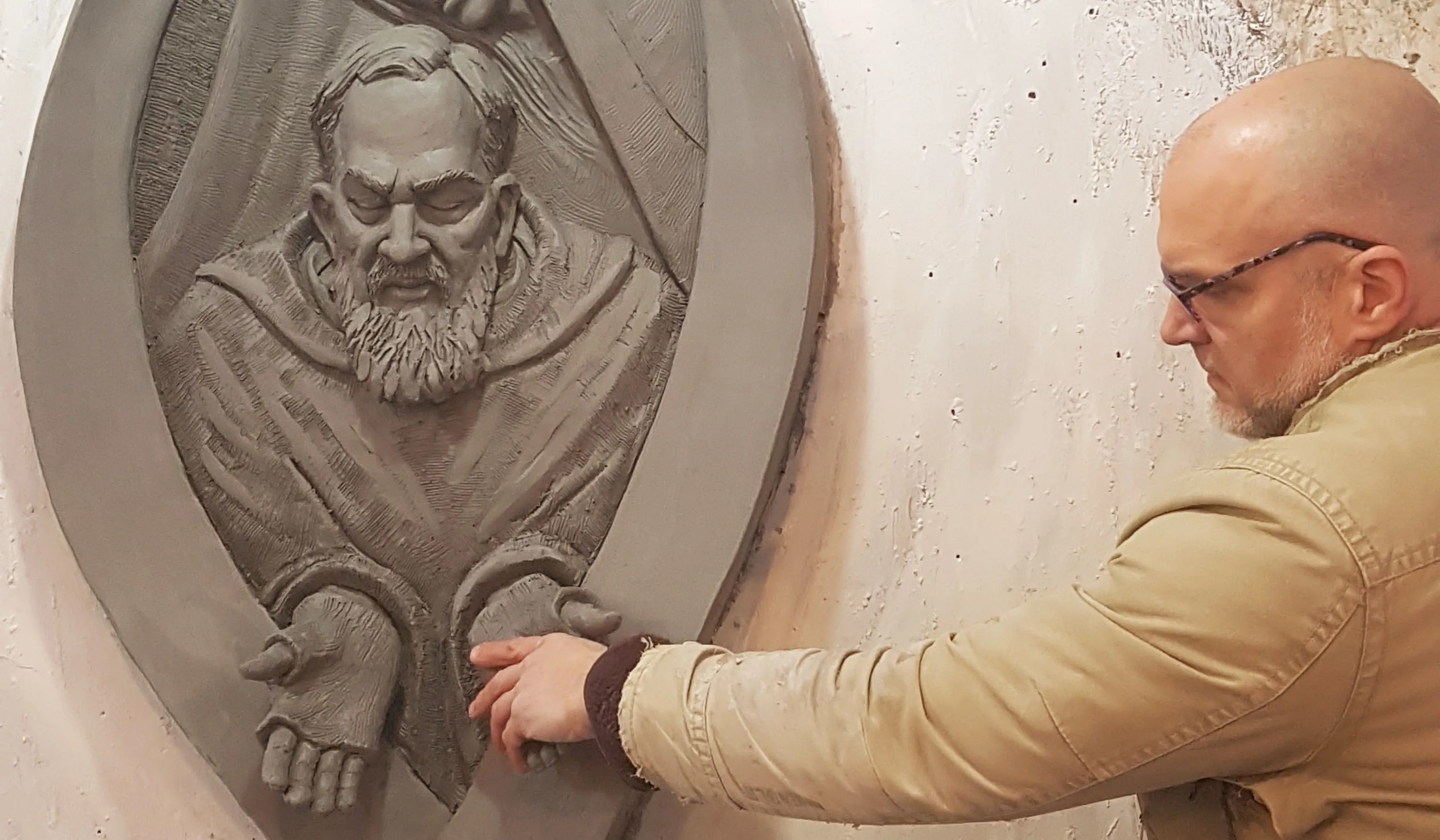 Artist Timothy P. Schmalz touches the hands of Padre Pio in one of his sculptures.?w=200&h=150