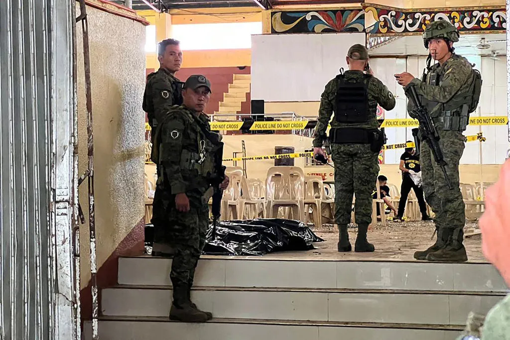 Military personnel stand guard at the entrance of a gymnasium while police investigators (background) look for evidence after a bomb attack at Mindanao State University in Marawi in the southern Philippines on Dec. 3, 2023.?w=200&h=150