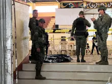 Military personnel stand guard at the entrance of a gymnasium while police investigators (background) look for evidence after a bomb attack at Mindanao State University in Marawi in the southern Philippines on Dec. 3, 2023.