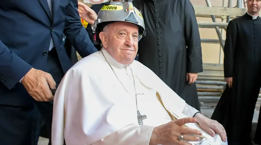 Pope Francis wore a hard hat while visiting the L'Aquila cathedral, which was damaged by a 2019 earthquake. Vatican Media