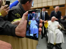 A person takes a photo of Pope Francis on a cell phone during a papal audience on Dec. 10, 2022.