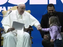 Pope Francis greets a young girl at a conference on Friday, May 10, 2024, on the state of birth rates in Italy and the wider West at the Auditorium della Conciliazione in Rome.