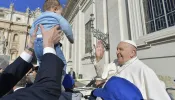Pope Francis blesses a baby at his Wednesday general audience on March 20, 2024, in St. Peter’s Square at the Vatican.