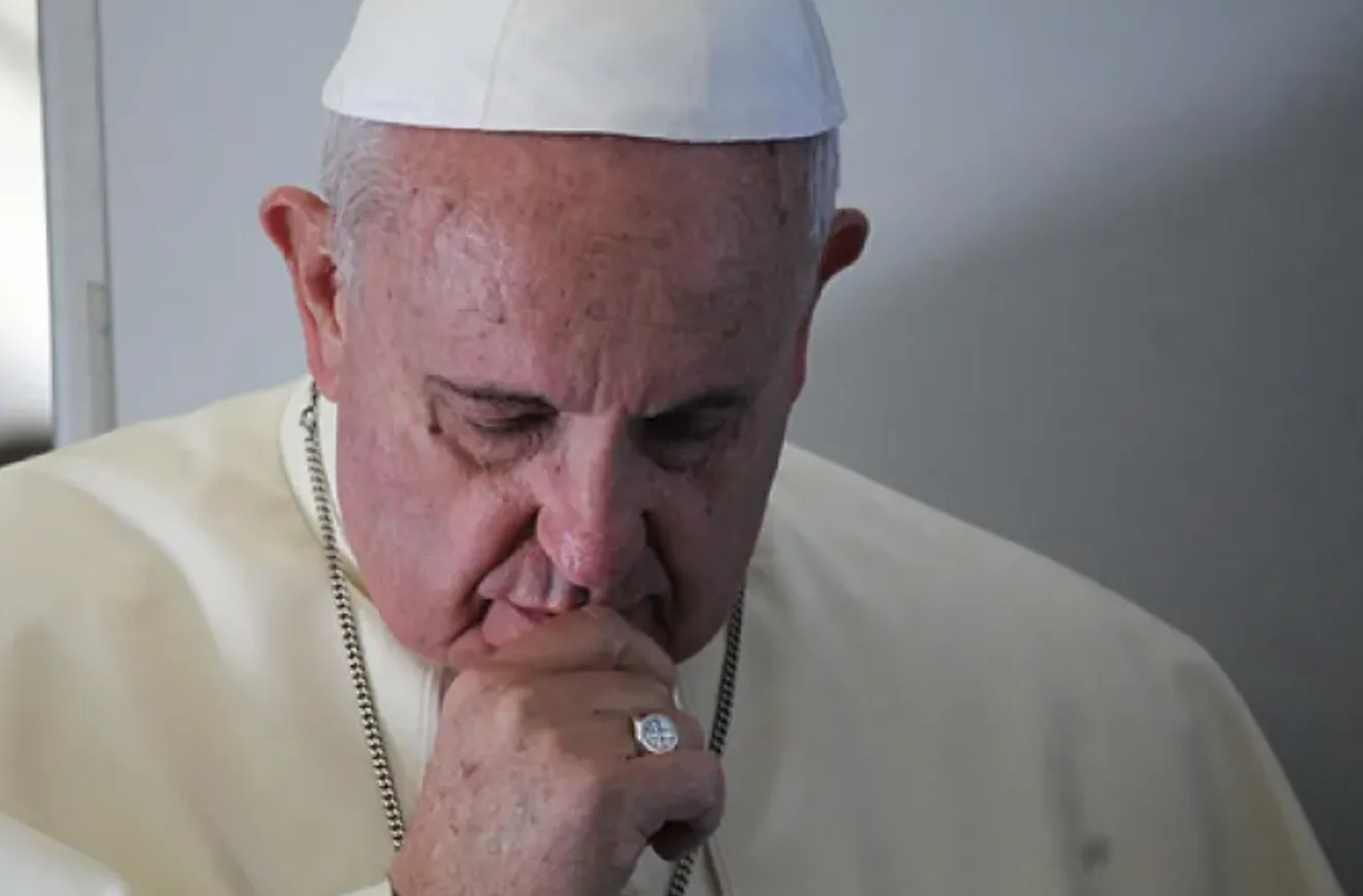 Pope Francis prays with journalists on a papal flight August 14, 2014.?w=200&h=150