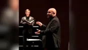 Richard Carrillo, director of “Requiem for the Forgotten,” conducts a choir. Carrillo is finishing his doctorate in choral conducting at the Frost School of Music at the University of Miami.