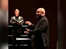 Richard Carrillo, director of “Requiem for the Forgotten,” conducts a choir. Carrillo is finishing his doctorate in choral conducting at the Frost School of Music at the University of Miami.