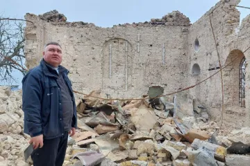Father Oleksandr Repin among the church ruins