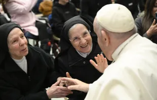 Pope Francis smiles with two religious sisters during his general audience on Jan. 11, 2023 Vatican Media