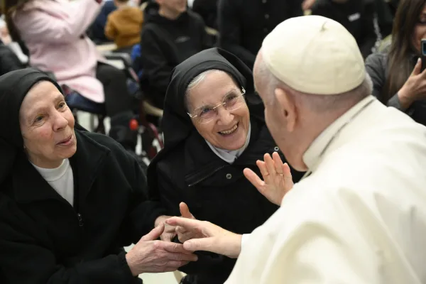 Pope Francis smiles with two religious sisters during his general audience on Jan. 11, 2023. Vatican Media