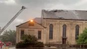 Firefighters work to put out a roof fire at historic St. James Catholic Church, in Rockford, Illinois, on Aug. 8, 2022. The Diocese of Rockford said a lightning strike was a possible cause.