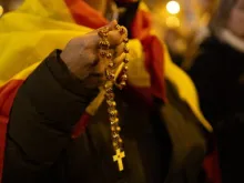 A man adorned in the flag of Spain prays the rosary for Spain on Dec. 8, 2023.