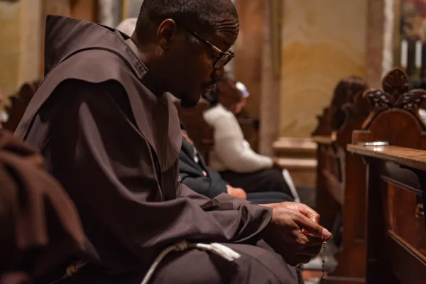 A Franciscan friar prays the rosary during a prayer service promoted by the Franciscan friars of the Custody of the Holy Land on Oct. 14, 2023, in St. Saviour's Church, Jerusalem.