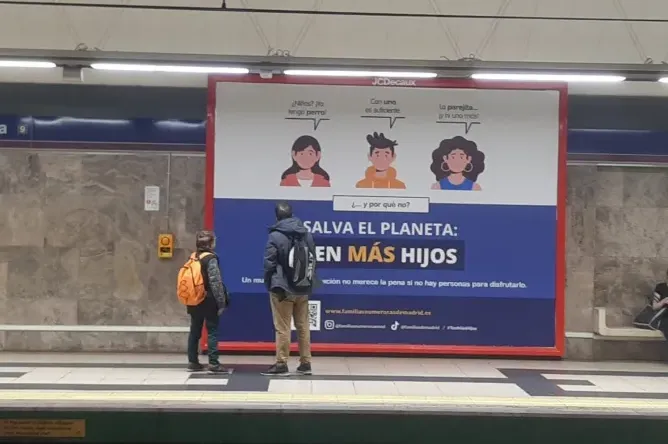 A father and son observe pro-natalist billboard campaign in Madrid, Spain.?w=200&h=150