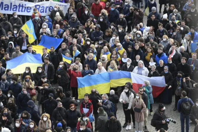 Pilgrims in St. Peter’s Square hold Ukrainian flags during Pope Francis’ Angelus address on Feb. 27, 2022