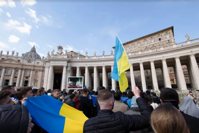 Pilgrims in St. Peter’s Square hold Ukrainian flags during Pope Francis’ Angelus address on Feb. 27, 2022