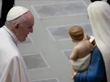 Pope Francis with a statue of the Virgin and Child.