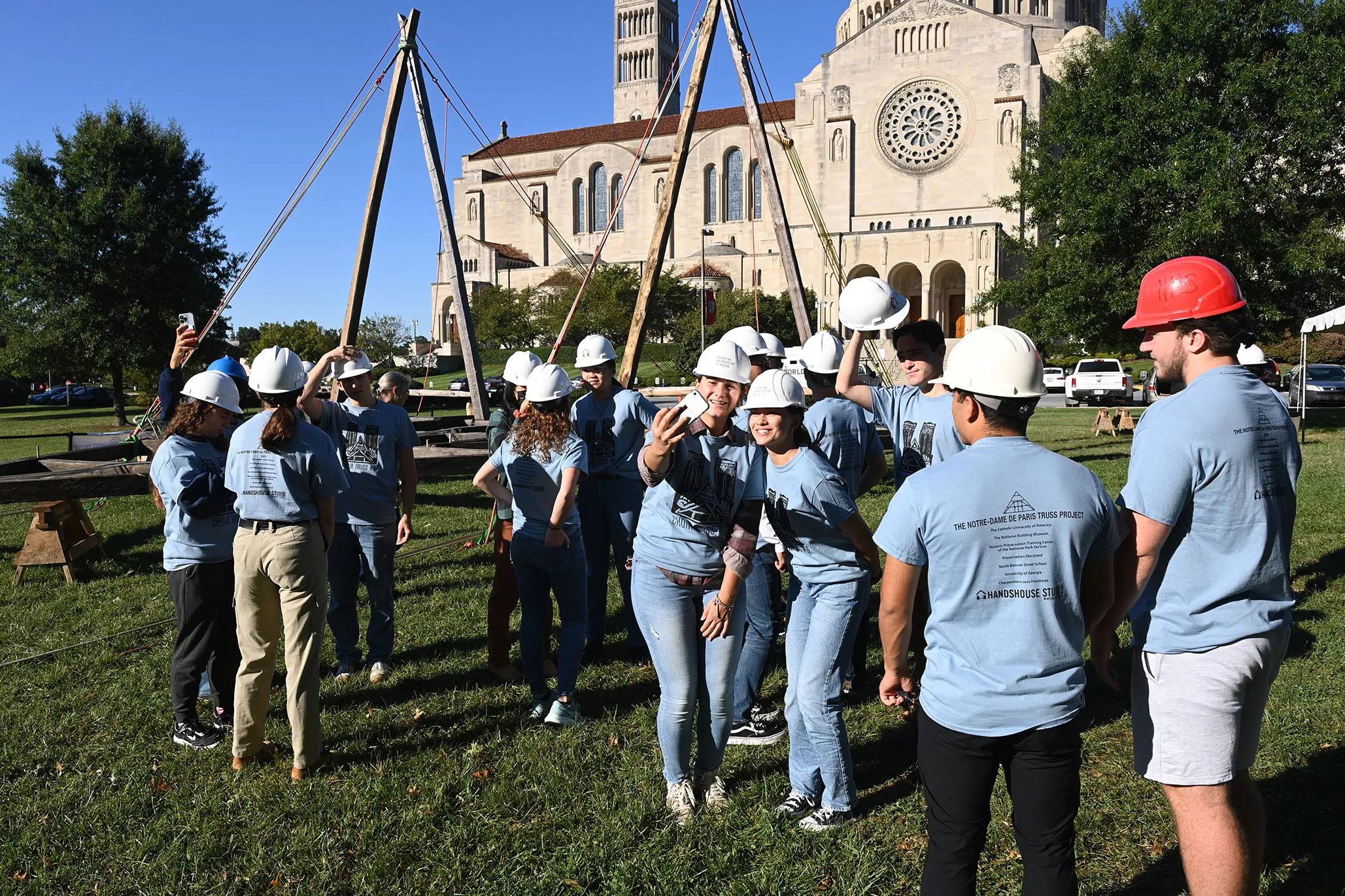 A group of volunteers stand in front of a Notre-Dame Cathedral truss replica at the Catholic University of America in Washington, D.C., on Sept. 26, 2022.?w=200&h=150