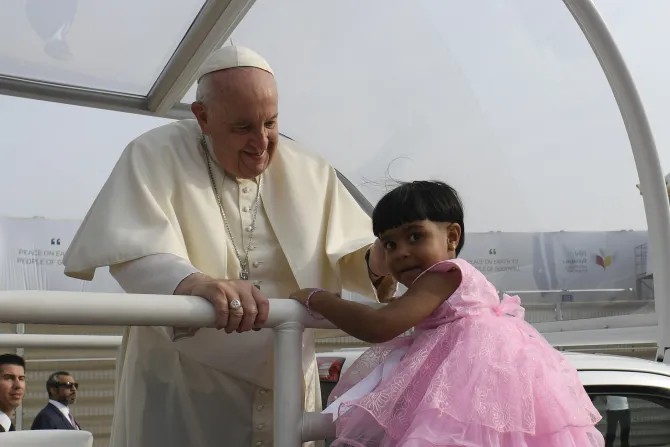 Pope Francis greets a young girl attending Mass at Bahrain's National Stadium on Nov. 5, 2022.